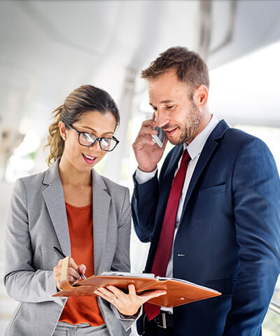 Cartera de Fondos de Inversión - Mujer con gafas sonriendo hablando con mujer joven sentadas en oficina