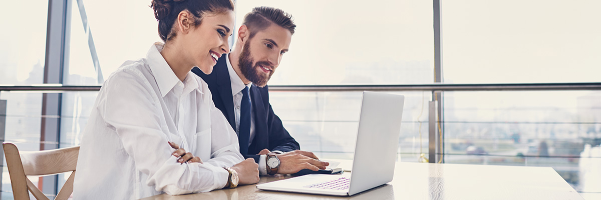 Fondos de inversión renta fija de Globalcaja Fondos de inversión renta fija - pareja de adultos jóvenes sonriendo viendo sus inversiones en el ordenador