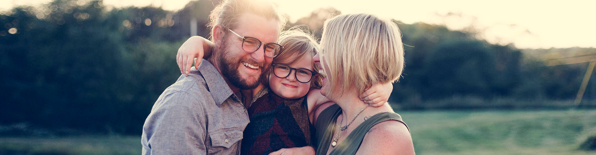 Familia con niño abrazado felices porque cuentan con un Seguro de Vida