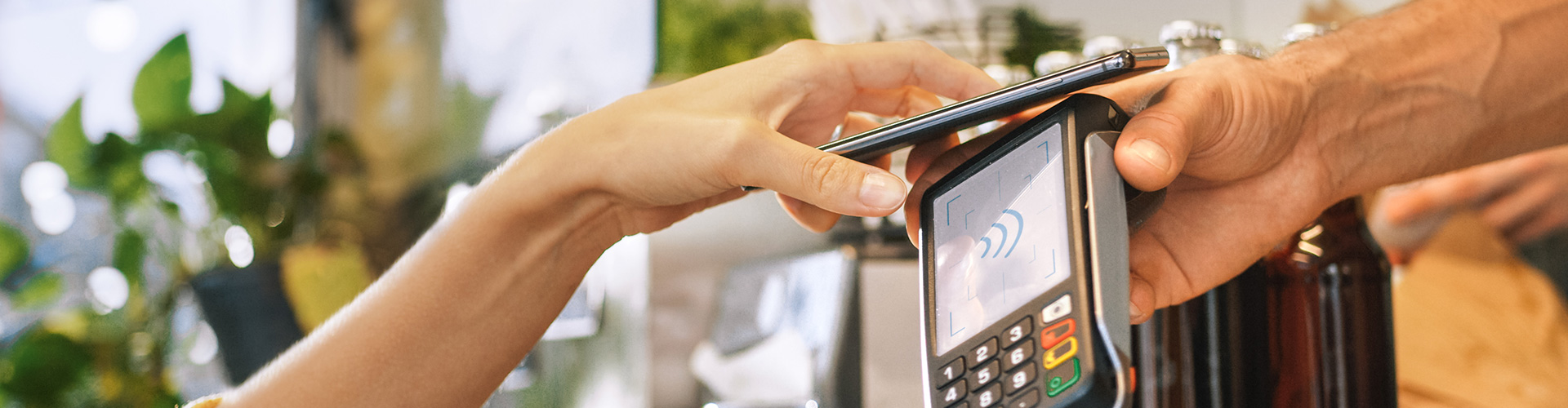 Forma de pago y cobro de Globalcaja Mano sujetando un móvil para realizar a través de NFC con un TPV de Globalcaja