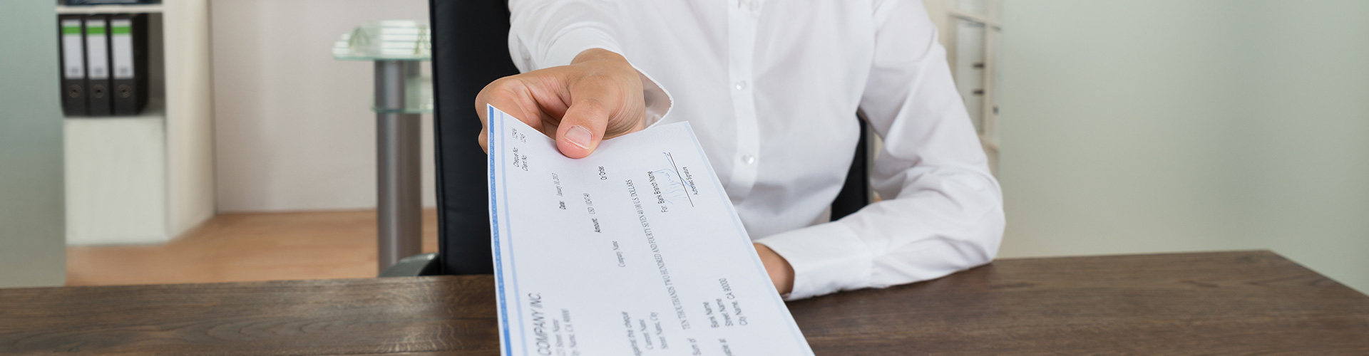 Servicio de ingreso de cheques online Globalcaja Persona entregando un cheque - Servicio de ingreso de cheque online