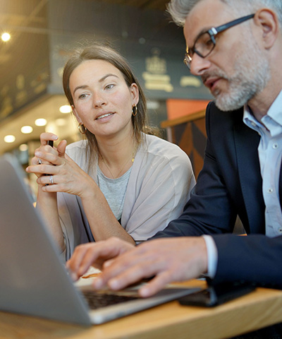 Hombre y mujer viendo ordenador en conjunto, analizando los seguros para autónomos de Globalcaja