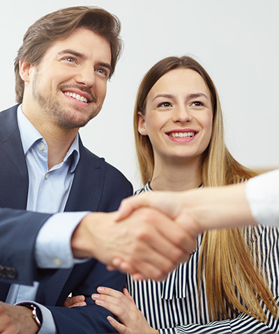 Opciones de carteras de inversión - Matrimonio contratando una cartera de inversión, con el chico tomando de la mano a ejecutivo bancario