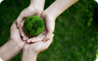 manos sostiene bola mundo verde compromiso globalcaja