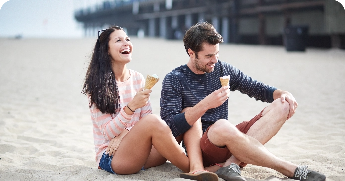 pareja come un helado en la playa gracias al préstamo personal amigo vacaciones de Globalcaja