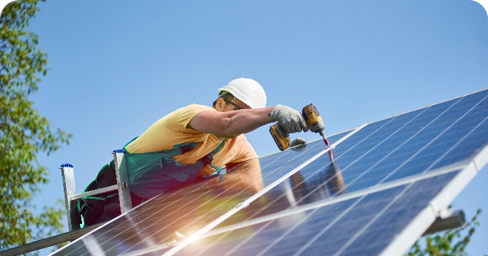 profesional de una instalación fotovoltaica vestido de amarillo instala una placa solar gracias al préstamo personal amigo verde de Globalcaja
