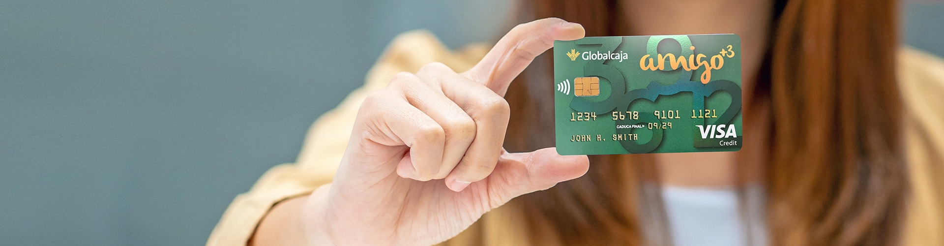 Chica sujetando tarjeta de crédito Amigo +3 de Globalcaja
