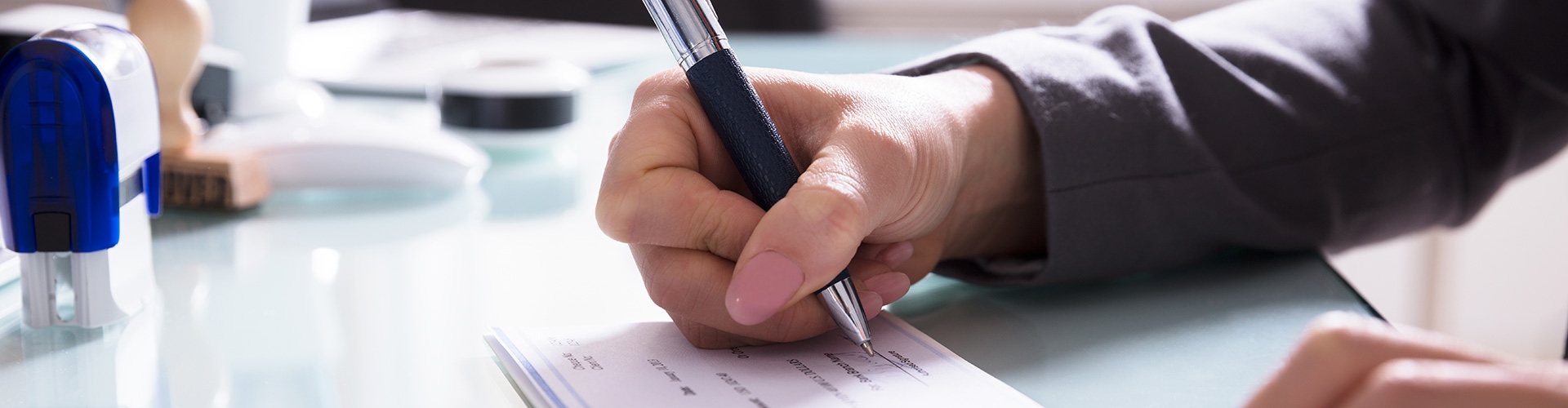 Ejecutiva de negocios vestida de traje, firmando un pago a proveedor internacional a través de los Créditos Documentarios de Globalcaja