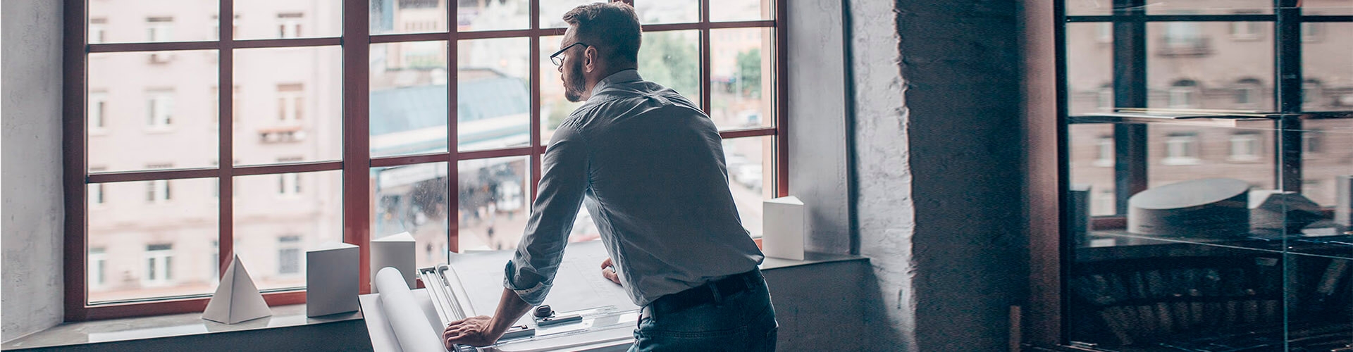 Financiación internacional con  anticipo de exportaciones- hombre con camisa en oficina mirando ventana