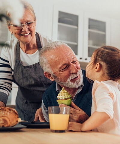 Mejores planes de pensiones - Abuelos felices dando obsequio a su nieta